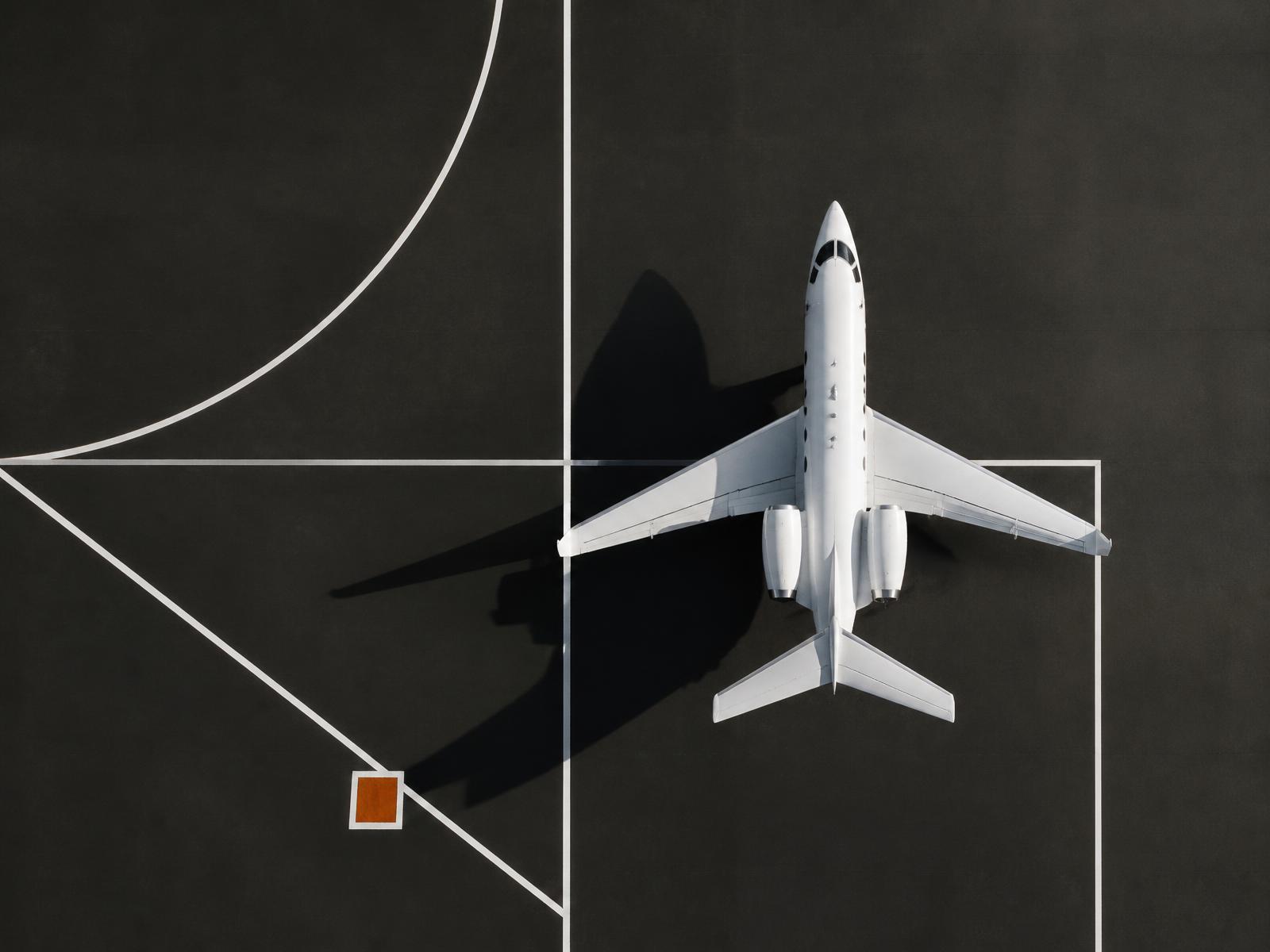 Top-down view of a private jet parked on a marked apron